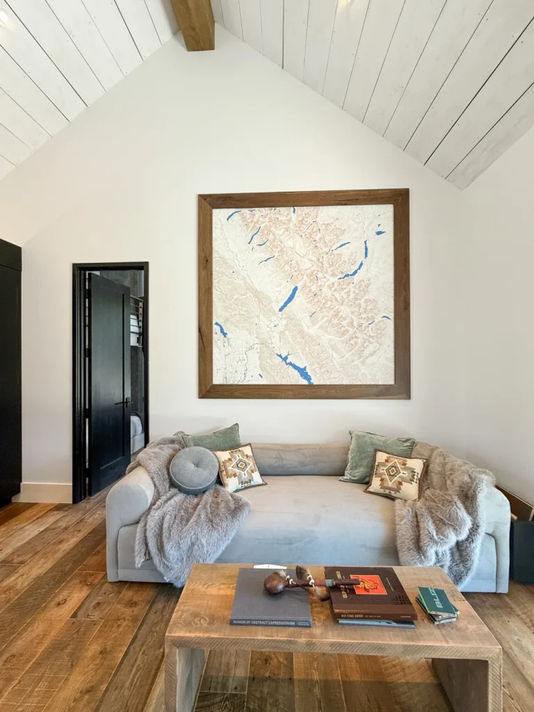 A sitting room at Halfmoon Camp with framed map artwork above the sofa